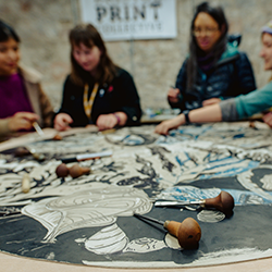 An image of people making a linocut print